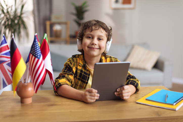 aluno estudando com tablet na mão e fone de ouvido